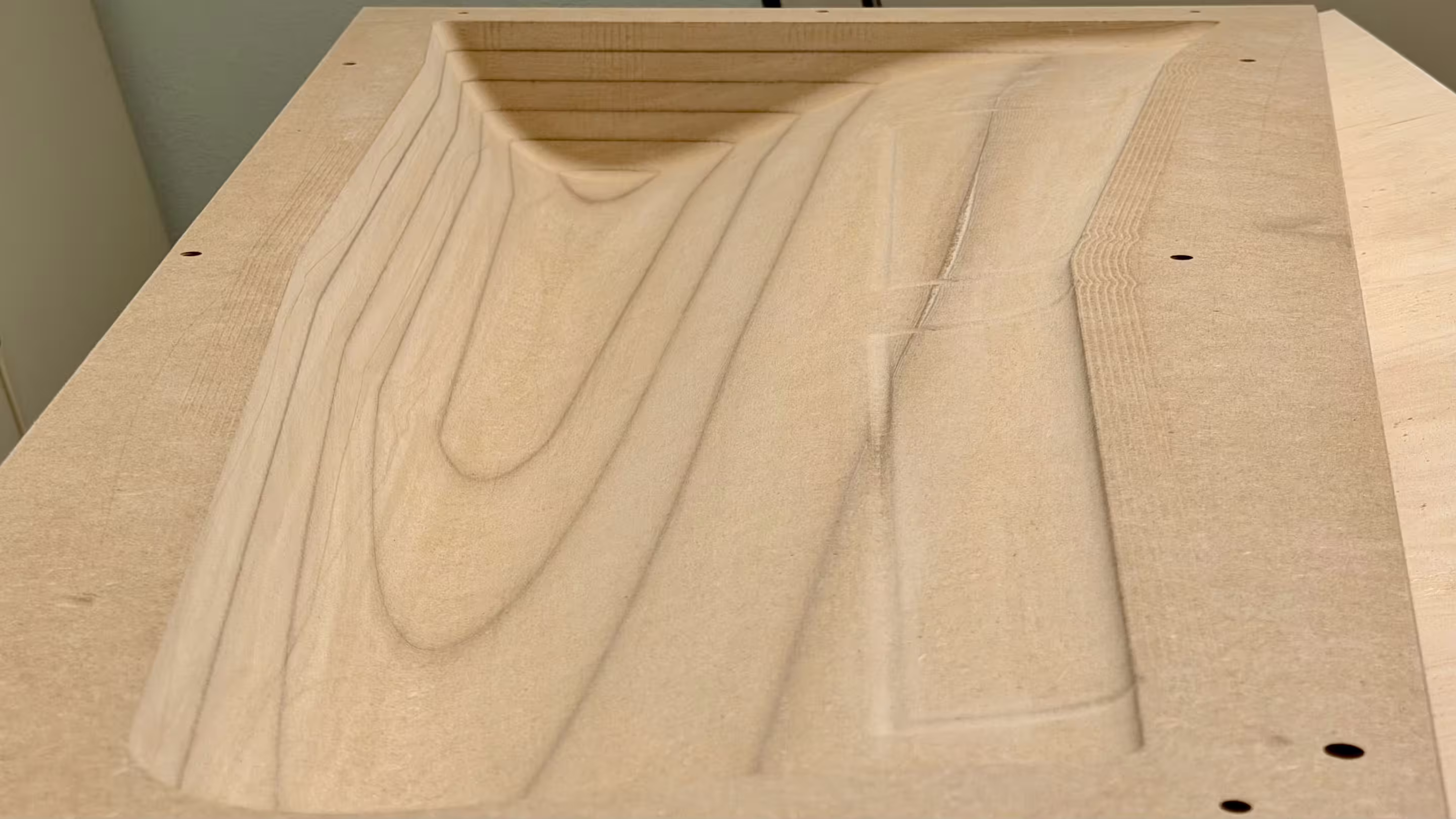 Fertig CNC-gefräste MDF-Negativform einer Tragfläche mit sichtbaren Schichtlinien vor Schleifen und Lackieren