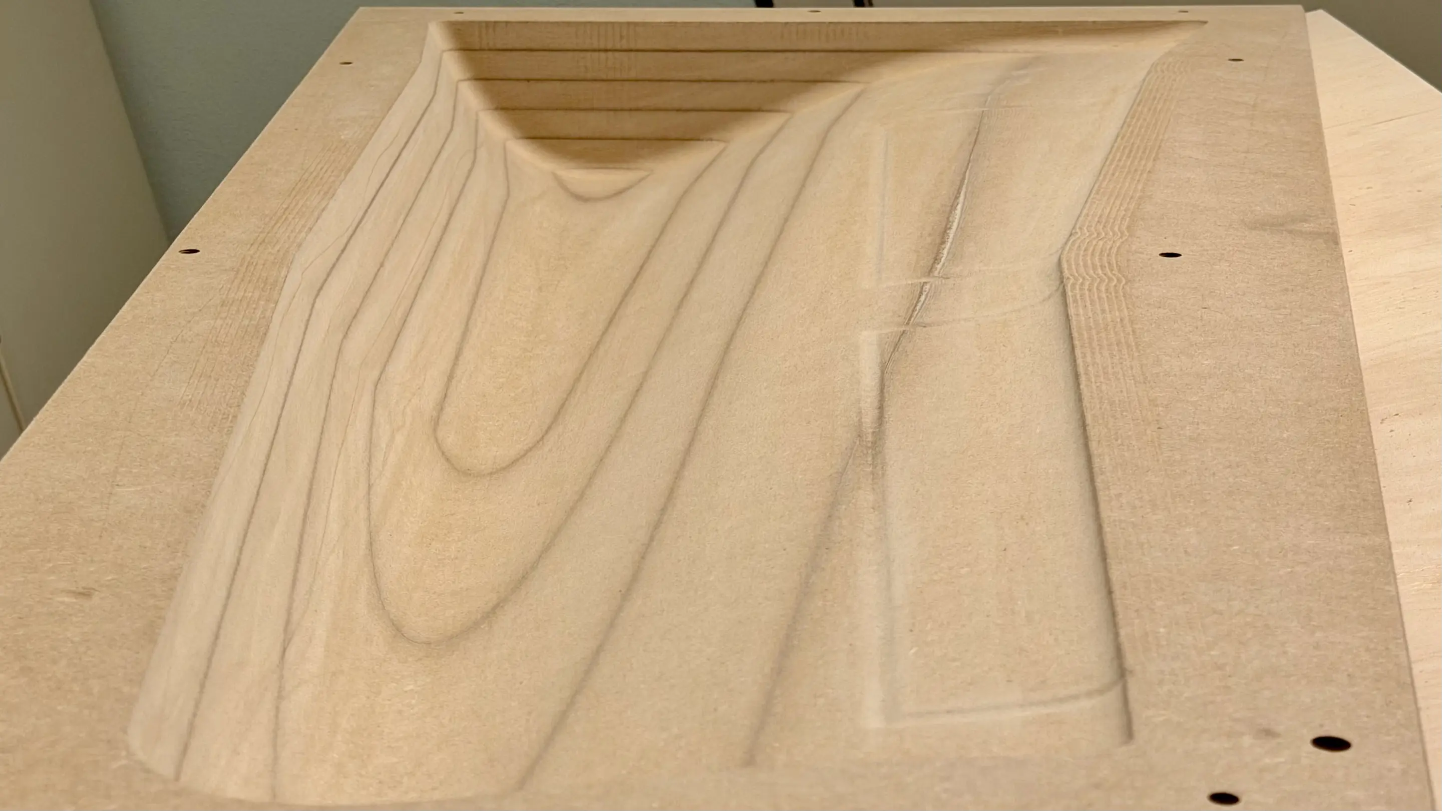Finished CNC-milled MDF negative mold of a wing with visible layer lines before sanding and painting